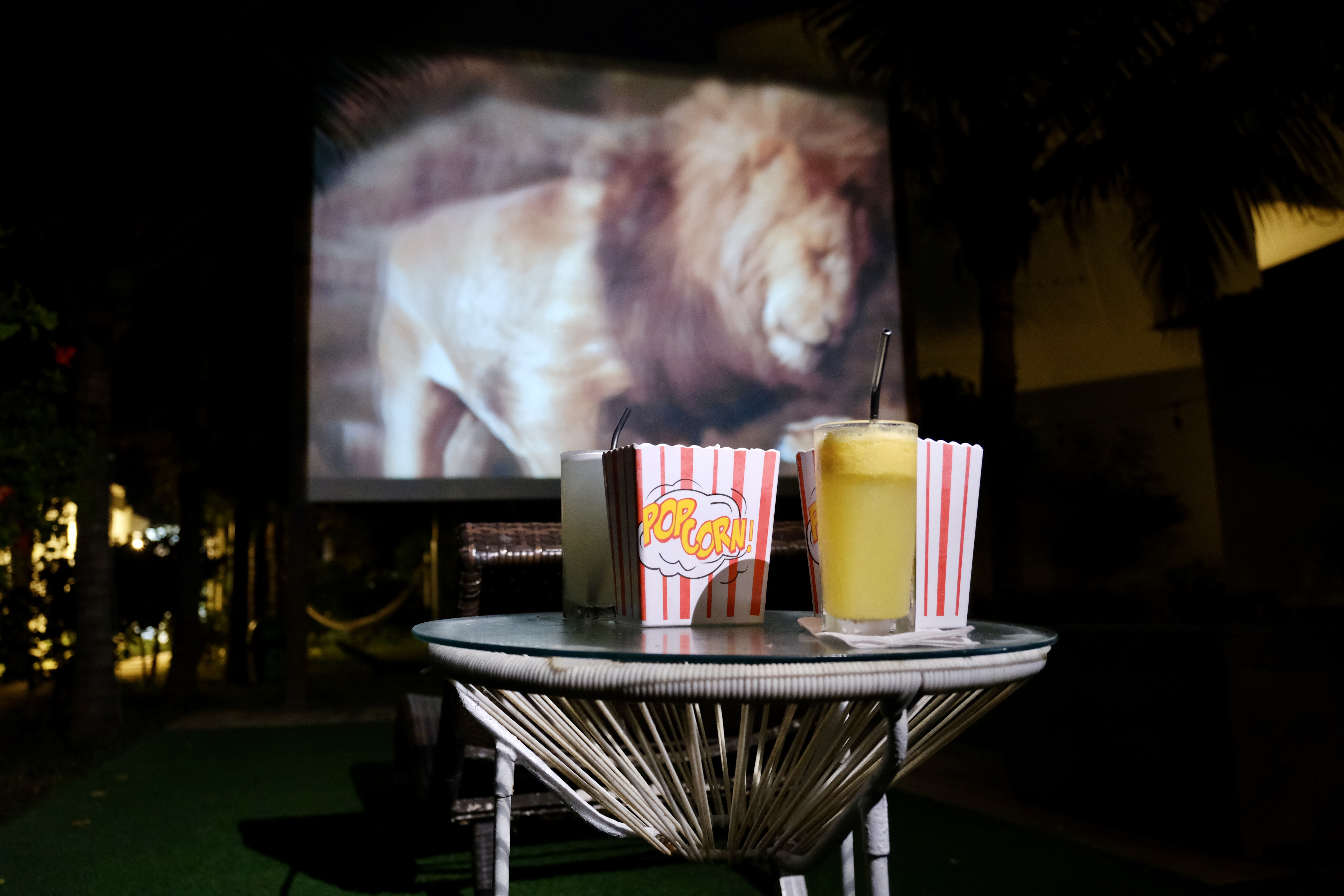 Cine al aire libre nocturno en Suites del Mar Máncora — palomitas, cóctel y película bajo las estrellas