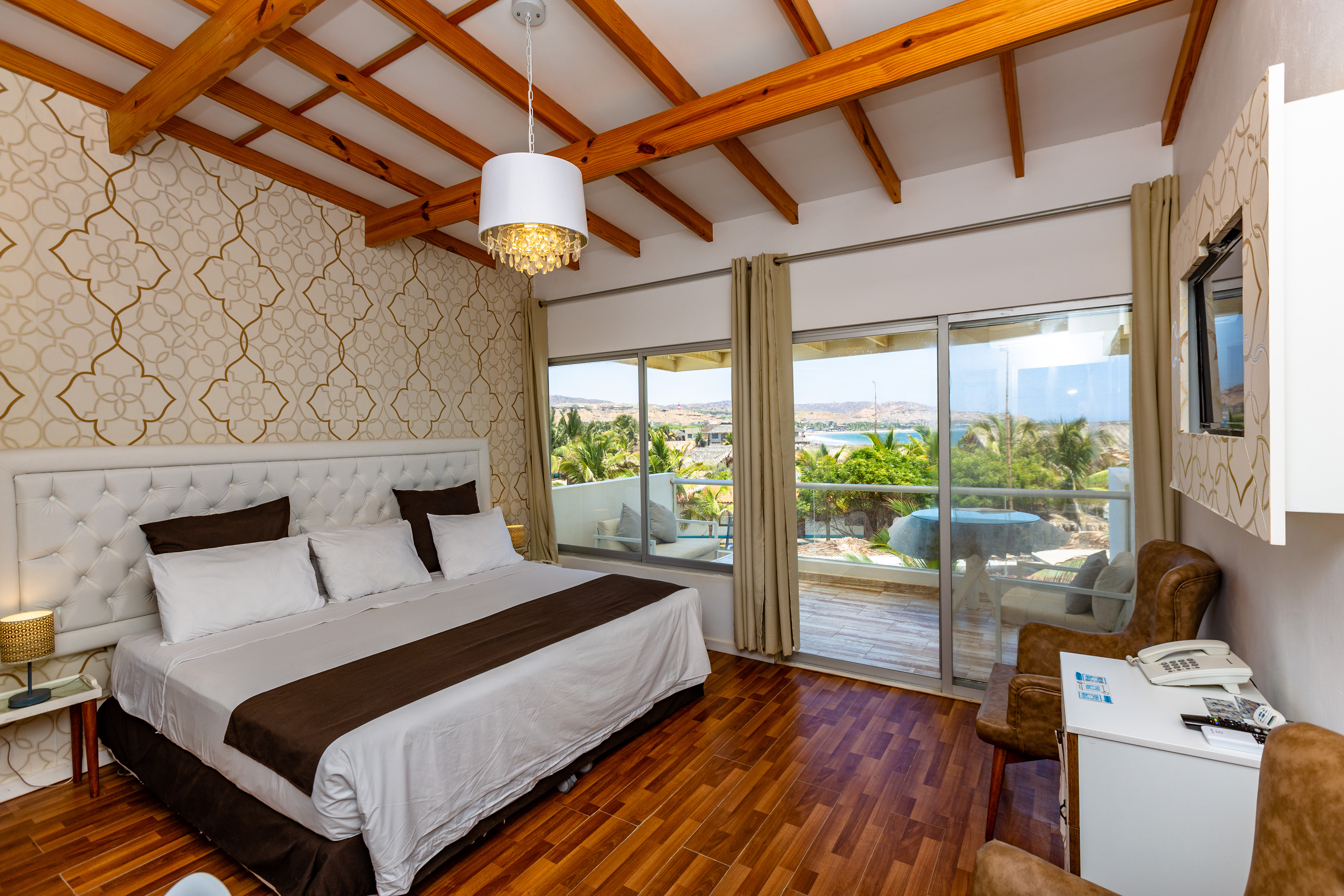 Dormitorio Junior Suite Premium con vigas de madera y vistas a la bahía